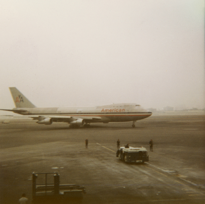Aircraft on runway in mid-20th-century setting